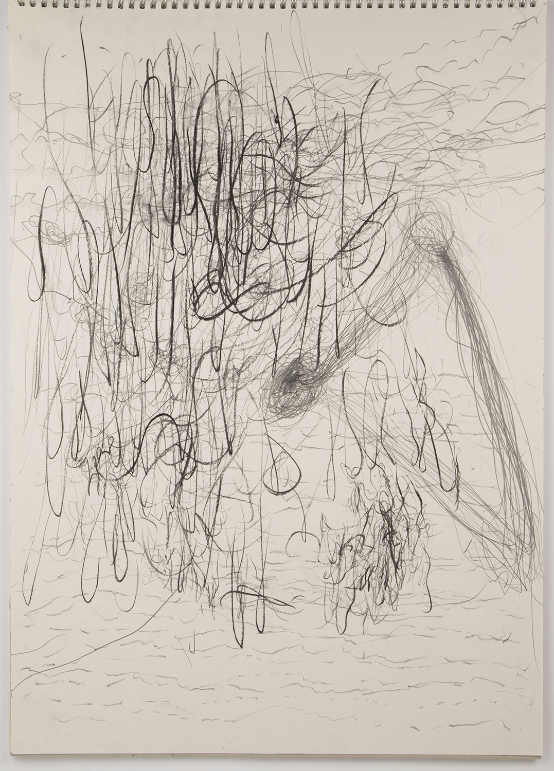 Chaotic black pencil scribbles fill a white paper, creating an abstract, dense, swirling pattern. The texture is energetic and expressive.